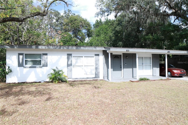 ranch-style house featuring a front lawn and a carport