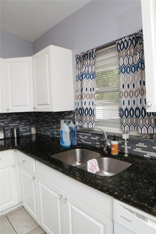 kitchen featuring white cabinets, dishwasher, light tile patterned flooring, and sink