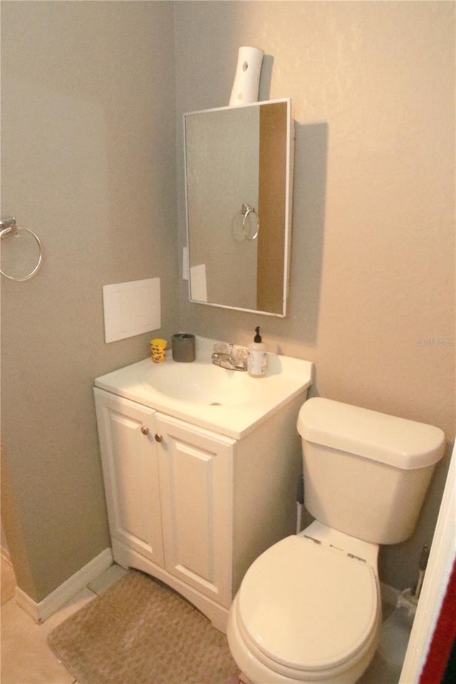 bathroom with tile patterned flooring, vanity, and toilet