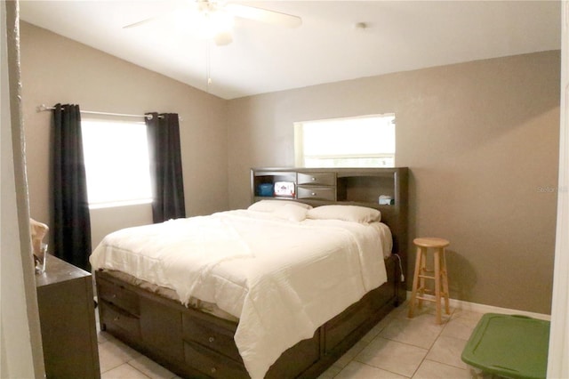 bedroom with ceiling fan, light tile patterned floors, and vaulted ceiling