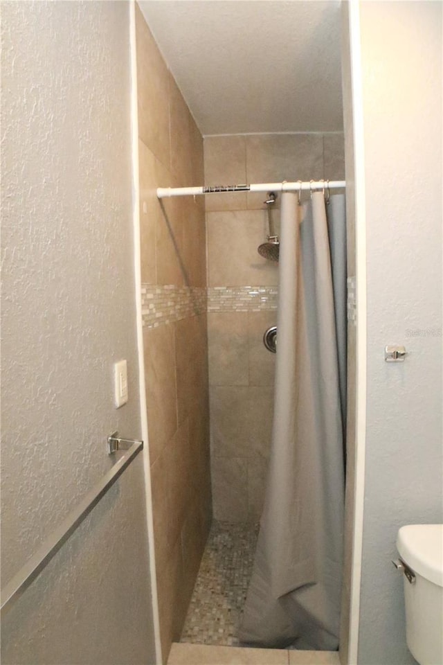 bathroom featuring a shower with curtain and toilet