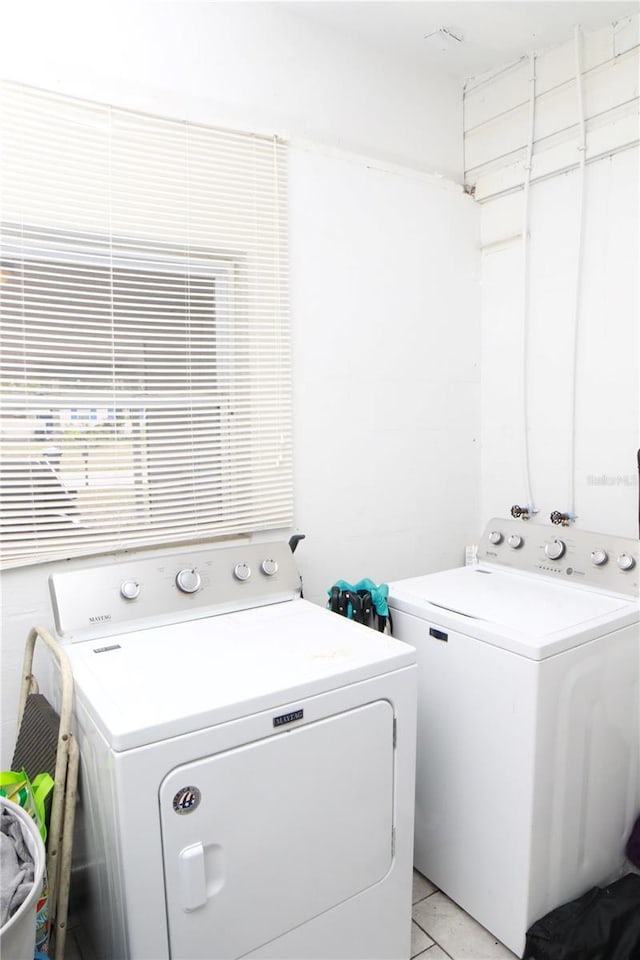 laundry area with separate washer and dryer and light tile patterned flooring