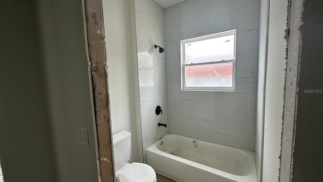 bathroom with toilet and tiled shower / bath