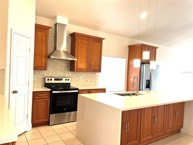 kitchen with sink, wall chimney exhaust hood, an island with sink, pendant lighting, and appliances with stainless steel finishes