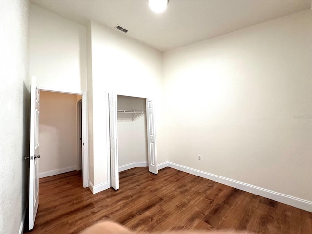 unfurnished bedroom with a closet and hardwood / wood-style floors