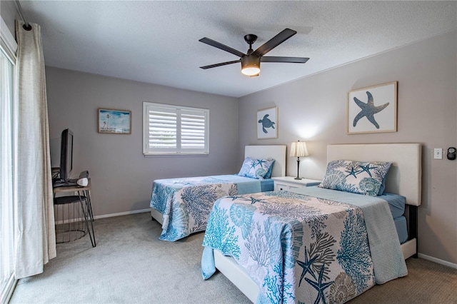 bedroom featuring carpet flooring, ceiling fan, and a textured ceiling