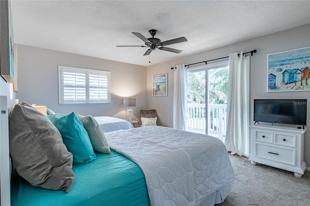 carpeted bedroom featuring access to exterior, a textured ceiling, and ceiling fan