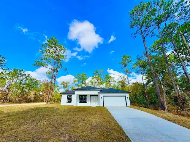 view of front of home with a front yard and a garage