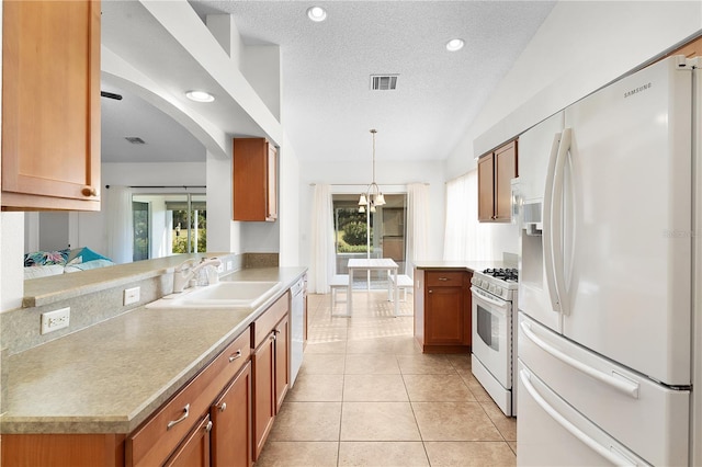 kitchen with kitchen peninsula, white appliances, sink, hanging light fixtures, and light tile patterned flooring