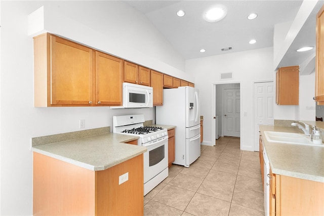 kitchen with lofted ceiling, sink, light tile patterned floors, and white appliances