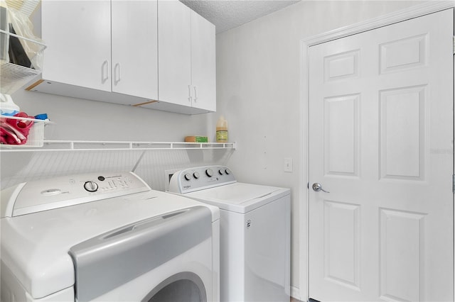 clothes washing area featuring cabinets, independent washer and dryer, and a textured ceiling