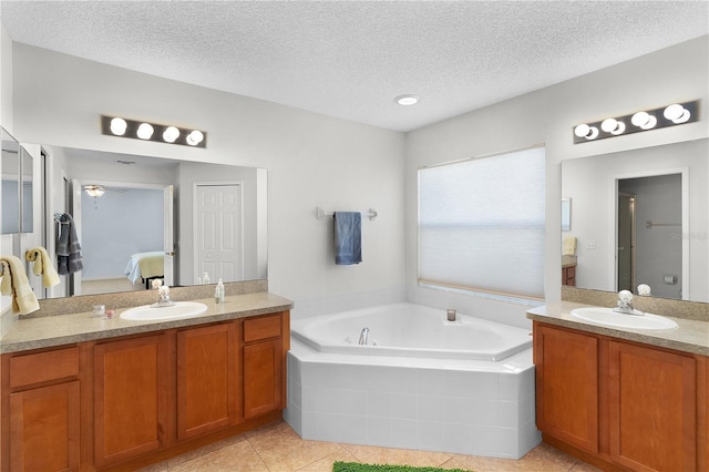 bathroom with ceiling fan, tile patterned floors, tiled bath, a textured ceiling, and vanity