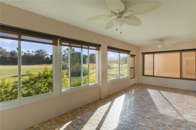 unfurnished sunroom with ceiling fan