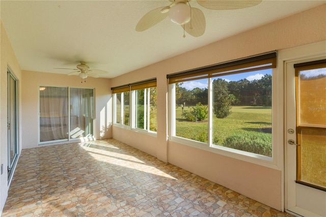 unfurnished sunroom with ceiling fan