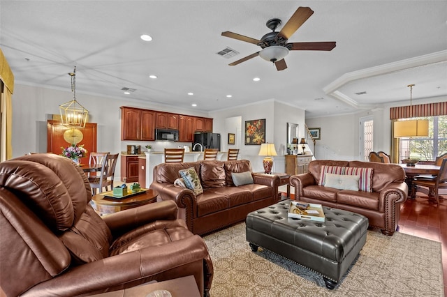 living room featuring light wood-type flooring, ceiling fan with notable chandelier, and ornamental molding