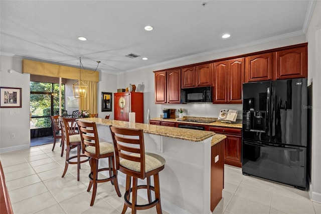 kitchen featuring decorative light fixtures, a center island, black appliances, a chandelier, and a breakfast bar area