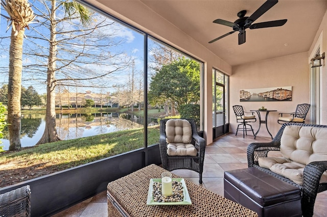 sunroom / solarium with ceiling fan and a water view