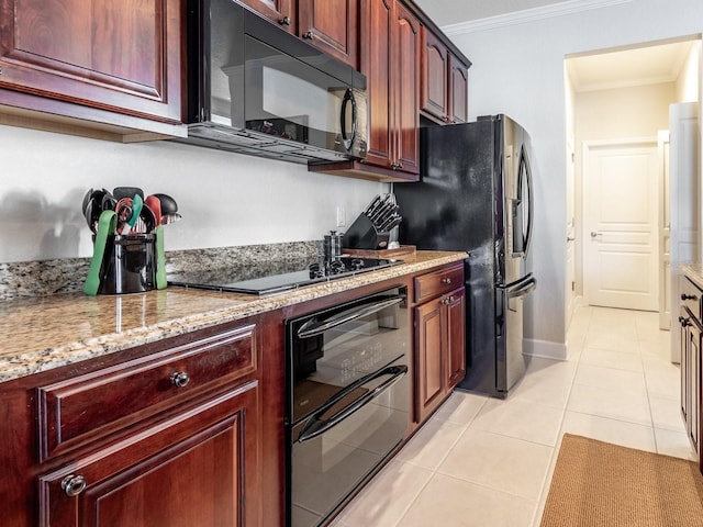 kitchen with light stone counters, light tile patterned floors, black appliances, and ornamental molding