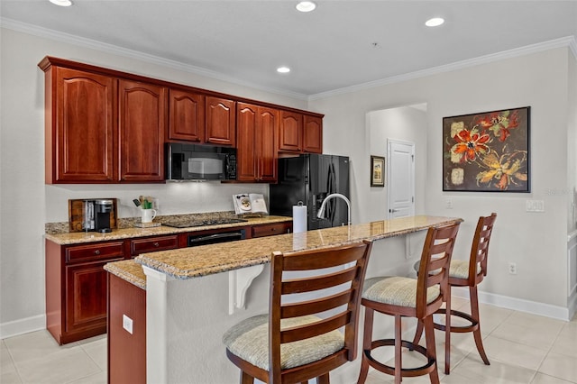 kitchen featuring a kitchen bar, black appliances, and crown molding