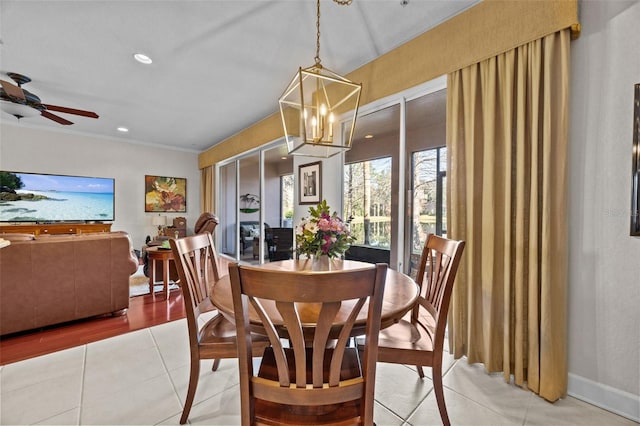 tiled dining area featuring ceiling fan with notable chandelier and ornamental molding