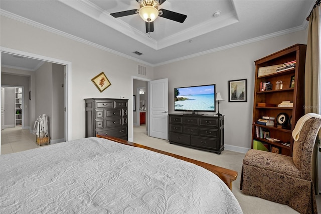 carpeted bedroom with ceiling fan, a tray ceiling, and ornamental molding