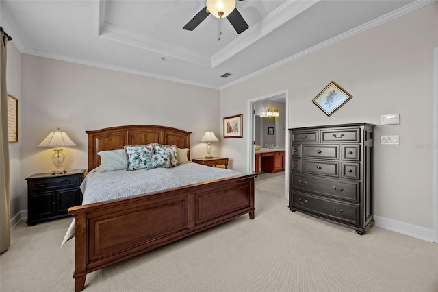 bedroom featuring connected bathroom, ornamental molding, ceiling fan, light colored carpet, and a tray ceiling