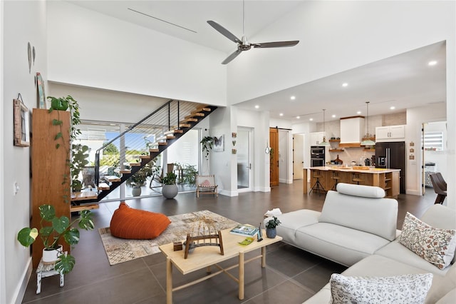 living room featuring a barn door, ceiling fan, and high vaulted ceiling