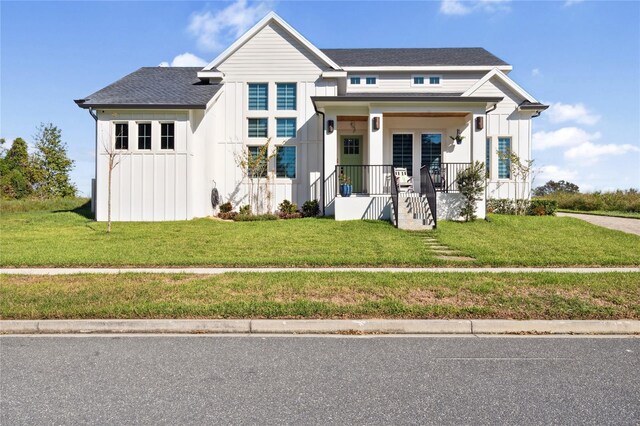 3705 Ridge Run Dr, Minneola, FL 34715 - modern farmhouse style home featuring board and batten siding, a porch, and a front lawn
