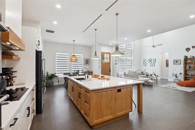 3705 Ridge Run Dr, Minneola, FL 34715 - kitchen with visible vents, a sink, black appliances, open floor plan, and an island with sink