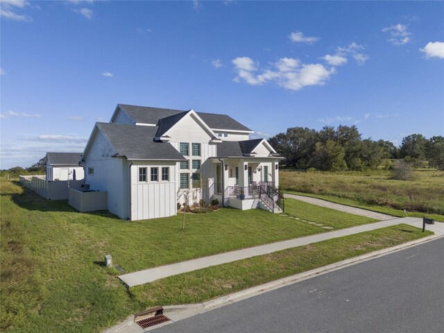 3705 Ridge Run Dr, Minneola, FL 34715 - view of front of house featuring a shingled roof, a front lawn, and board and batten siding