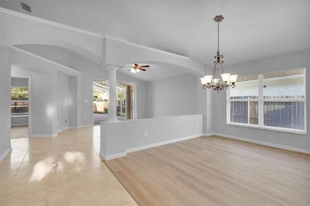 tiled spare room with ceiling fan with notable chandelier, lofted ceiling, and decorative columns