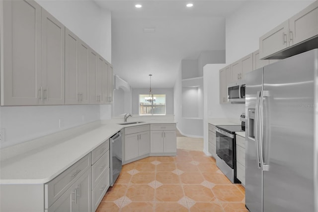 kitchen with sink, hanging light fixtures, light tile patterned floors, appliances with stainless steel finishes, and kitchen peninsula