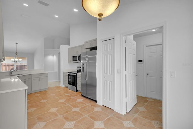 kitchen featuring stainless steel appliances, sink, decorative light fixtures, an inviting chandelier, and gray cabinets