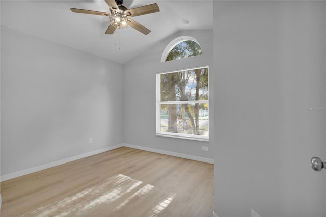 empty room with ceiling fan, light wood-type flooring, and vaulted ceiling