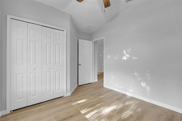 unfurnished bedroom featuring ceiling fan, a closet, vaulted ceiling, and light wood-type flooring