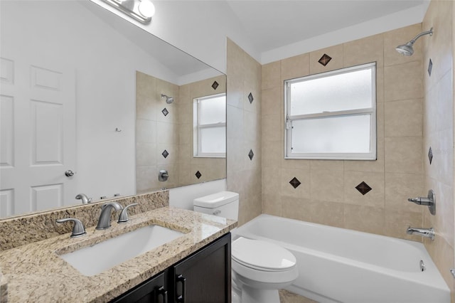 full bathroom featuring tiled shower / bath, vanity, and toilet