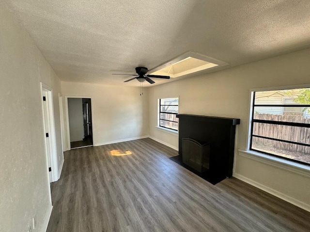 unfurnished living room featuring dark hardwood / wood-style flooring, a textured ceiling, and ceiling fan