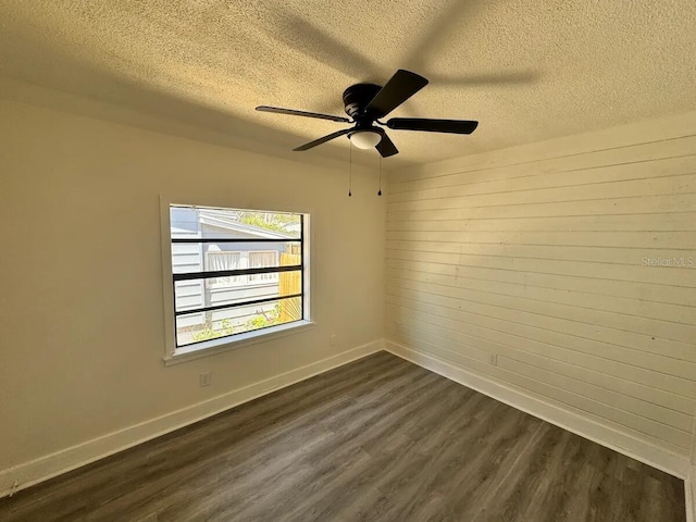 empty room featuring ceiling fan, dark hardwood / wood-style flooring, and a textured ceiling