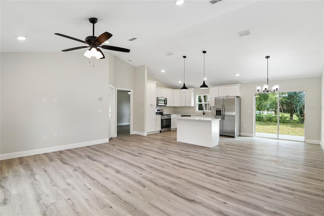 kitchen with appliances with stainless steel finishes, ceiling fan with notable chandelier, pendant lighting, white cabinets, and a center island