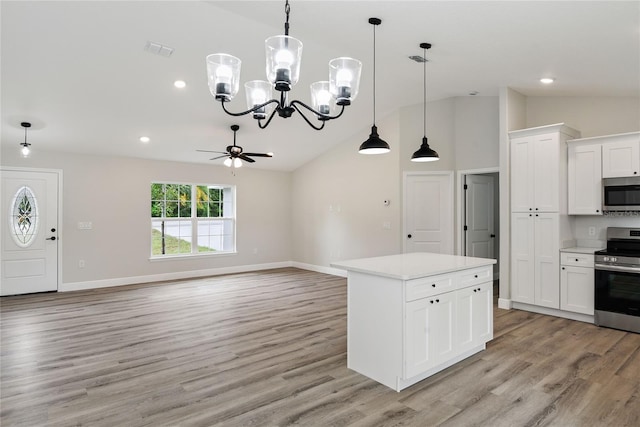 kitchen with lofted ceiling, white cabinets, ceiling fan with notable chandelier, hanging light fixtures, and stainless steel appliances