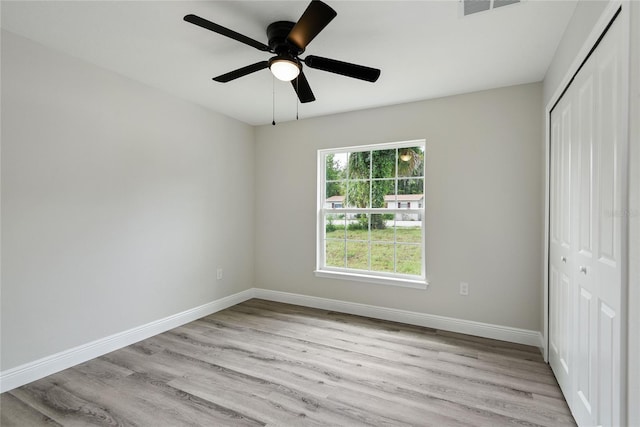 unfurnished bedroom with ceiling fan, a closet, and light hardwood / wood-style floors