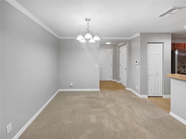 carpeted spare room with a notable chandelier and crown molding