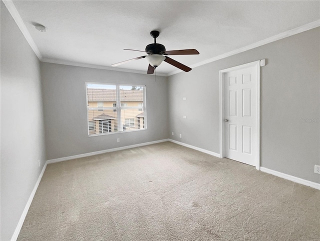 unfurnished room with carpet, ceiling fan, and crown molding