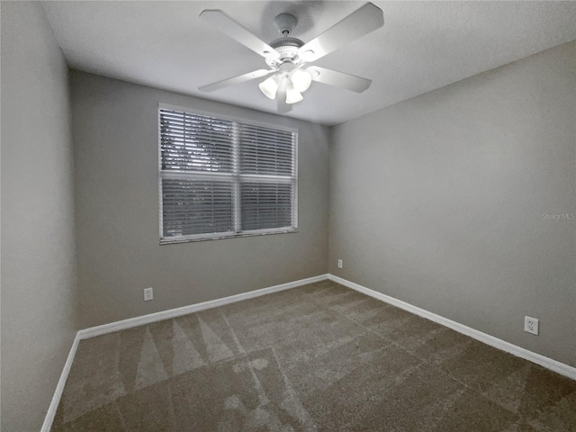 carpeted spare room featuring ceiling fan