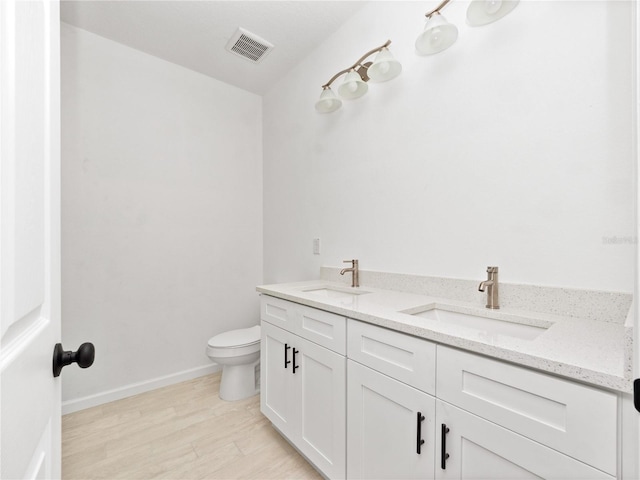 bathroom featuring hardwood / wood-style flooring, vanity, and toilet