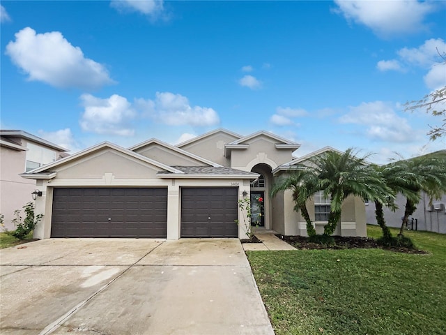 view of front of property with a garage and a front lawn