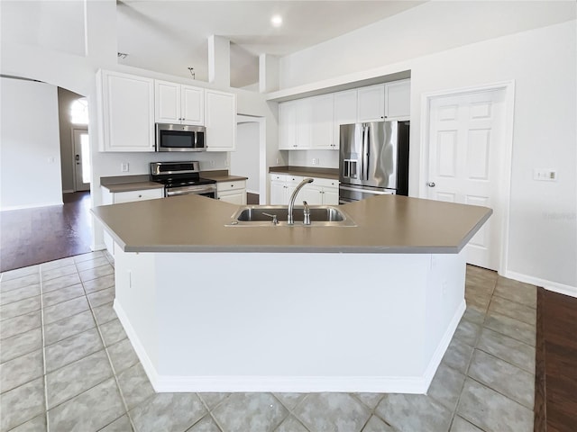 kitchen with a large island, sink, white cabinets, and appliances with stainless steel finishes