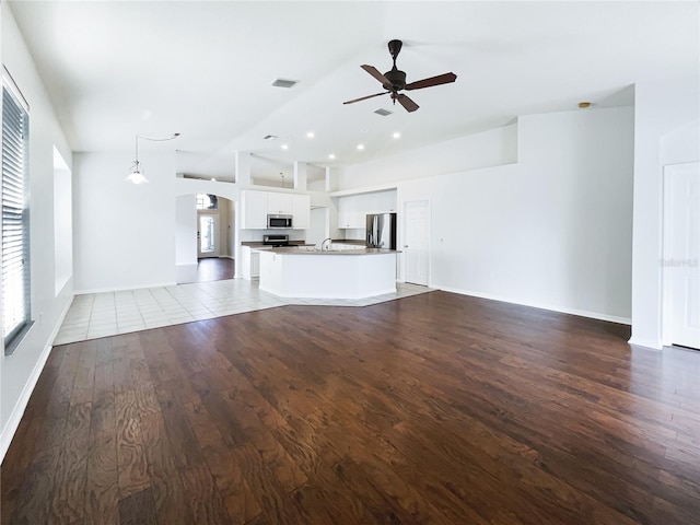 unfurnished living room with ceiling fan, hardwood / wood-style floors, and sink