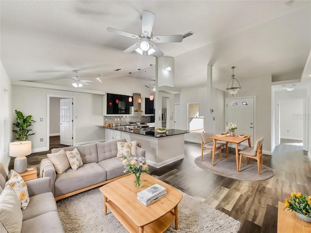 living room featuring dark hardwood / wood-style floors, ceiling fan, and lofted ceiling