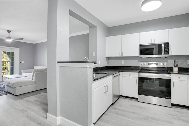 kitchen featuring white cabinets, ceiling fan, light wood-type flooring, and appliances with stainless steel finishes